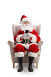 © Ljupco Smokovski - Santa claus sitting in armchair and rusing a smartphone