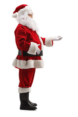 Wall Mural - Full length profile shot of santa claus standing and waiting with arm forward