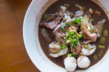 Wall Mural - Close up of a bowl Thai style beef noodle soup. Selective focus