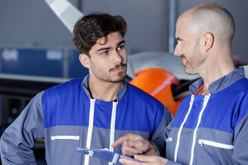 Wall Mural - two aircraft mechanics are talking