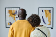 © AnnaStills - Rear view of multiethnic young couple embracing and enjoying art together at gallery