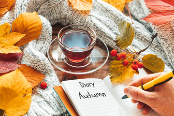 Autumn season, Diary opening a new chapter of life, entitled Autumn, A cup of hot tea, Beautiful colorful leaves, warm sweater, Moody atmosphere, Lifestyle concept