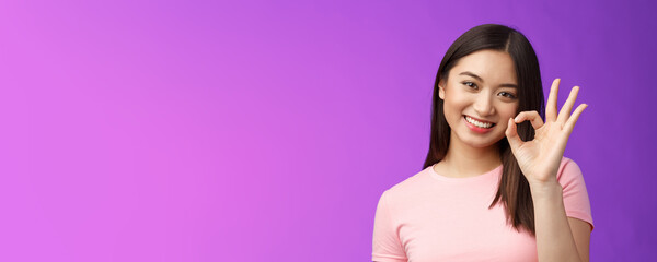 Wall Mural - Cute smiling asian girl approve good plan, show okay ok sign, tilt head lovely grinning, satisfied perfect quality product, give positive feedback, accept choice, stand purple background