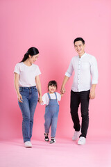 Wall Mural - happy young asian family image, isolated on pink background