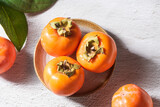 Ripe persimmon or kaki fruit on table.