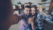 © silverkblack - Point of view shot of happy young couple taking selfie with house keys after purchasing new apartment. Young people are holding camera posing and kissing with boxes in background.