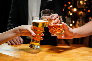 food and drink male friends are happy drinking beer and clinking glasses at a bar or pub.