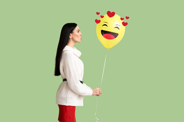 Sticker - Beautiful young woman holding balloon with drawn smile on green background