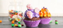 Tasty Halloween Cupcakes And Candies On Table, Closeup