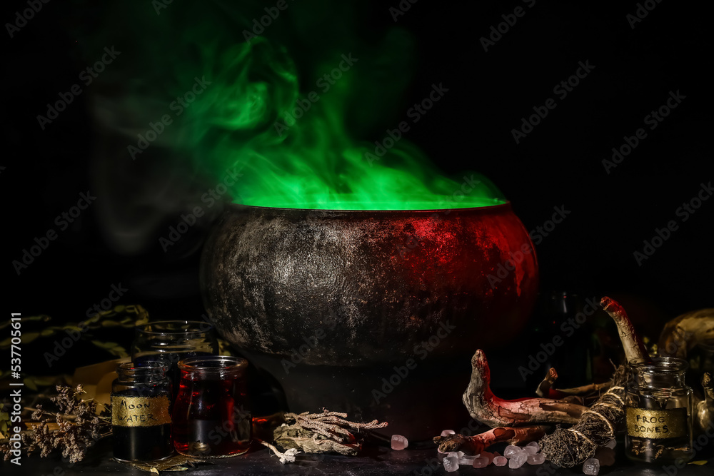 Witch's cauldron with potion and magic attributes for ritual on dark background