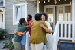 © Seventyfour - Big African American family embracing outdoors welcoming guests for housewarming party