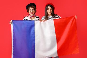 Wall Mural - Young women with flag of France on red background