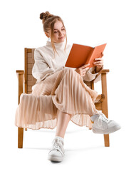 Poster - Pretty young woman reading book in armchair on white background