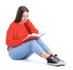 Wall Mural - Young woman in red sweater reading book on white background