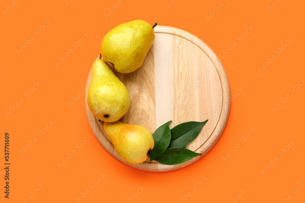 Wooden board with ripe pears on color background