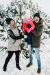 © Serhii - Happy family near decorated Christmas tree having fun in a winter forest. Mom, dad and daughter playing in snow, walking in mountains.  Winter holidays, Merry Christmas and new year concept.
