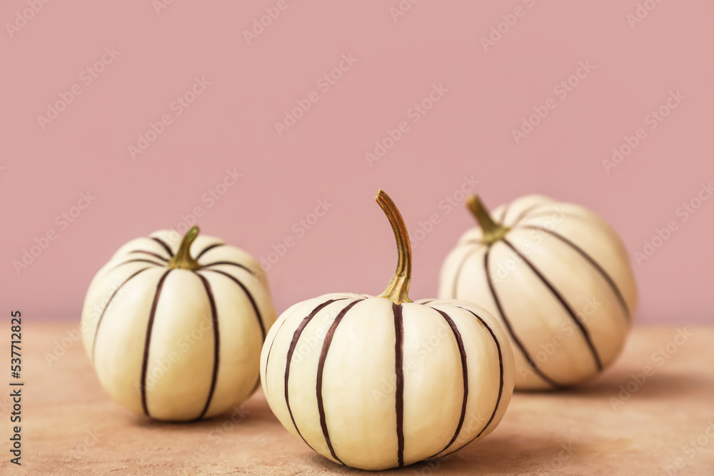 Painted Halloween pumpkins on color background
