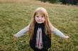 © Serhii - Child in autumn mountains. Girl is running on the grass in the field and enjoying nature. Little hiker and traveler walk on top of foggy mountain. World Tourism Day. Active outdoor games. Closeup.