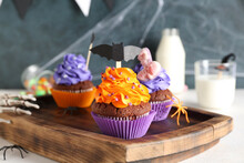 Board With Tasty Halloween Cupcakes On White Table, Closeup