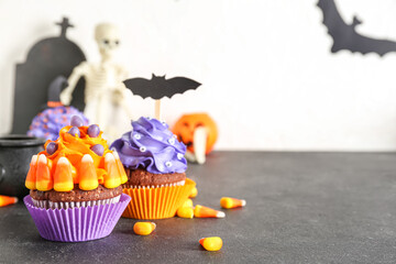 Wall Mural - Tasty Halloween cupcakes with candy corns on dark table, closeup