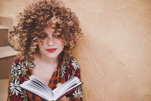 Happy Woman With Curly Hair Reading Book
