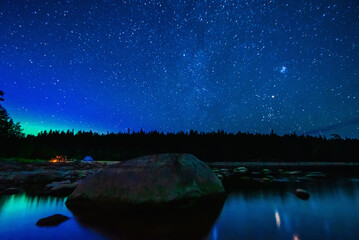 Wall Mural - starry sky with constellations, galaxies, milky way and many stars above water of river with stones 