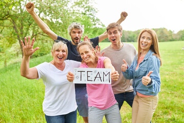 Group of young people celebrating success and holding a sign