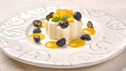 Wall Mural - Panoramic view panna cotta homemade with natural vanilla pod, mango syrup, grape and mint, close up