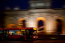 Public Transport Bus Circulating In Front Of The Puerta De Alcalá In The City Of Madrid