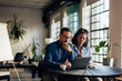 © bnenin - Male boss working online while his female client sitting next to him.