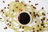 Fototapeta Mapy - Christmas New Year coffee concept. Cup of black espresso coffee decorated as christmas tree ball. Golden Christmas tree beads. White background