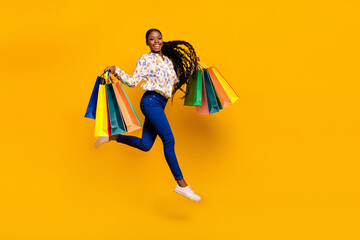 Canvas Print - Full length body size view of attractive cheery girl jumping carrying new things order isolated over bright yellow color background