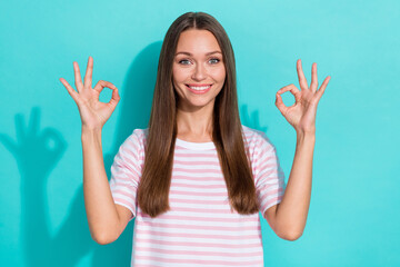 Wall Mural - Photo of good mood optimistic girl with long hairstyle wear striped t-shirt showing okey symbol isolated on turquoise color background