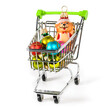Supermarket trolley with the glass x-mas fir tree toys and bear. Shopping cart with gift isolated on white background. Christmas shopping concept.