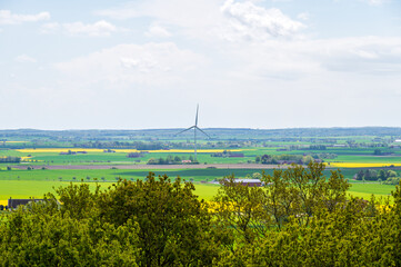Wall Mural - Big wind power plant in flat farmland landscape in Skåne Sweden during spring