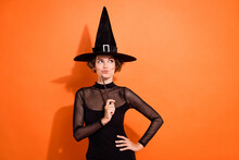 Photo Of Cute Young Woman Look Empty Space Hold Wand Study At Hogwarts Wear Stylish Halloween Witch Outfit Isolated On Orange Background