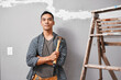 © Meeko Media - A confident Asian man holds hammer with arms crossed ready for home DIY