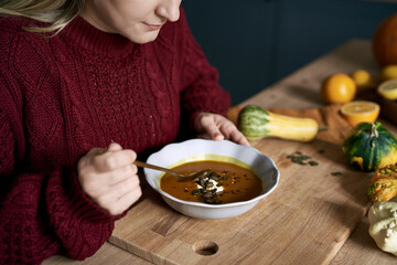 Close up of caucasian woman start eating warming pumpkin soup