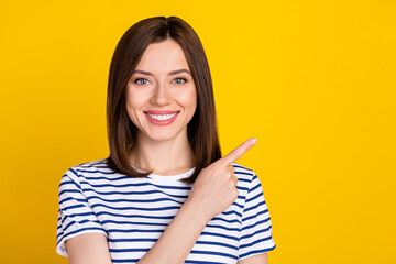 Poster - Portrait of gorgeous nice lovely woman straight hairdo dressed striped t-shirt directing empty space isolated on yellow color background