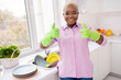 Photo of satisfied cheerful neat lady two arms fingers demonstrate thumb up doing dishes kitchen indoors