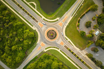Canvas Print - Aerial view of road roundabout intersection with moving cars traffic. Rural circular transportation crossroads