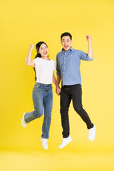 Wall Mural - full body image of asian couple posing on yellow background
