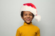© millaf - Portrait of happy little black kid boy in Santa hat smiling on white background