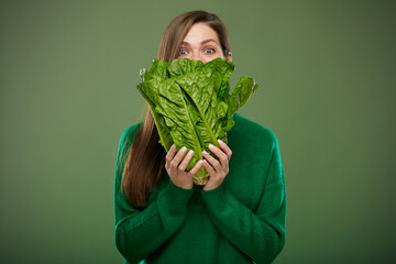 Woman covering face with salad. Advertising female portrait on green.