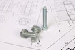 © bayurov - Technical drawings of bolt and nut. Engineering, technology and metalworking. Metal bolt and nut on printed drawings background.