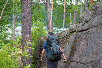 Hiker on the hiking trail in the forest in Määkijänniemi, Repovesi National park on summer day