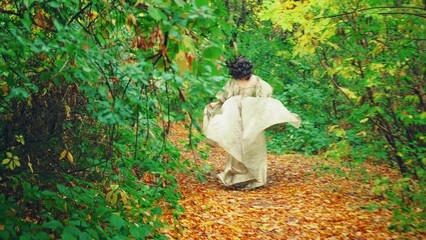 Wall Mural - Princess girl runs in autumn park, steps on fallen yellow orange leaves of tree forest path, Vintage golden dress fabric train fly in motion. Escape of fantasy woman queen. Back view. Autumn nature