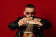 © MartaKlos - guitarist showing his instrument to the camera, perspective view. Isolated on a red background