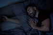 © Home-stock - Close-up of handsome bearded man sleeping in bed at home enjoying good sleep, top view, copy space