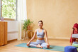 © ALTO IMAGES/Stocksy - Cheerful young woman at start of yoga session